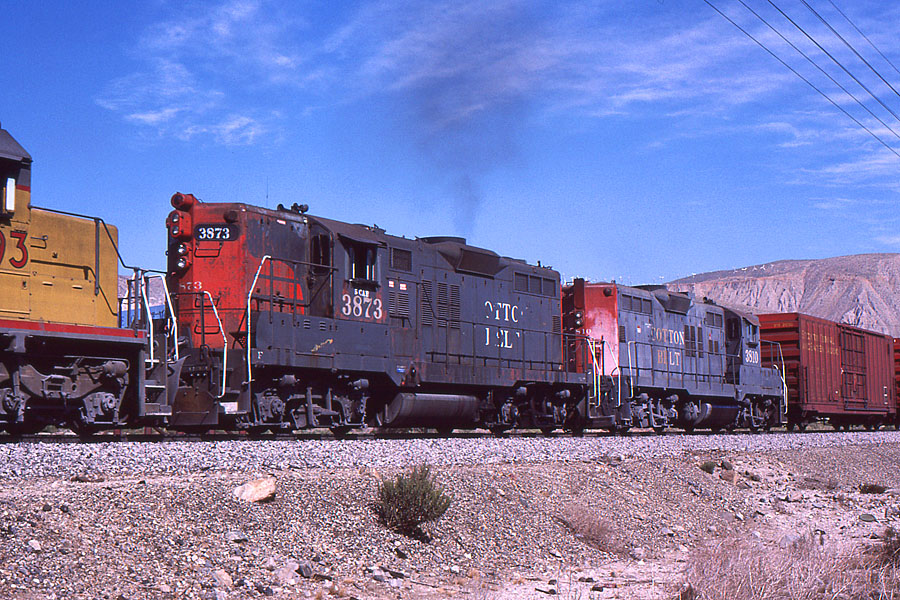 SSW 3873 serves as a head-end helper on a westbound manifest train on the east side of Beaumont Hill in October of 1987. Note the "5 CAB" stencil above the number referring to its ability to accommodate a 5 man crew (part of the elimination of cabooses). Photo by John L. Shine