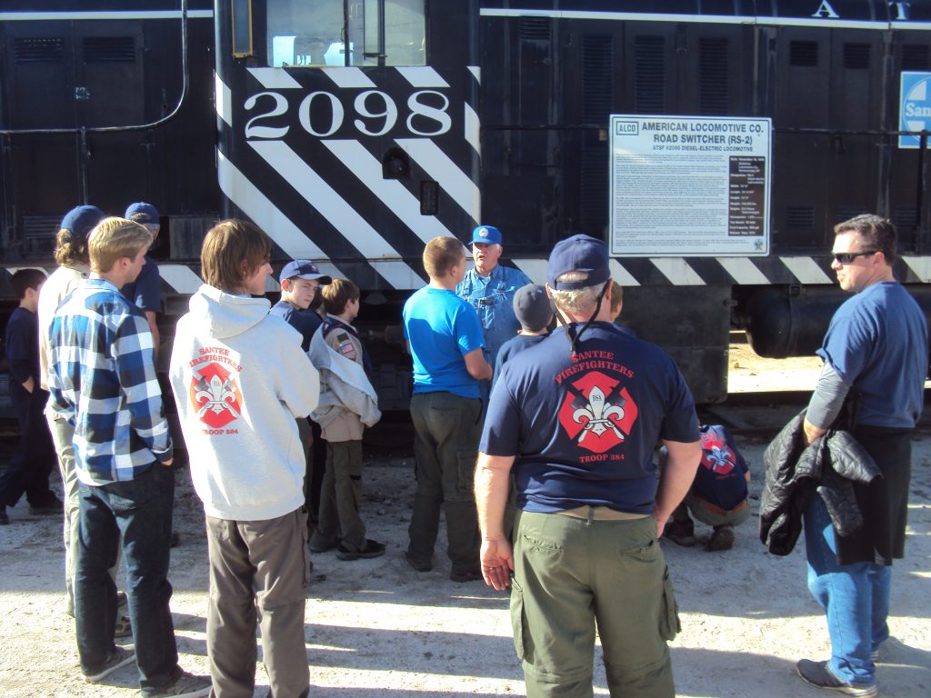 Scouts from Troop 384 from Santee, CA ask Scouting Coordinator Glen Rogers about one of the Museum's locomotives.